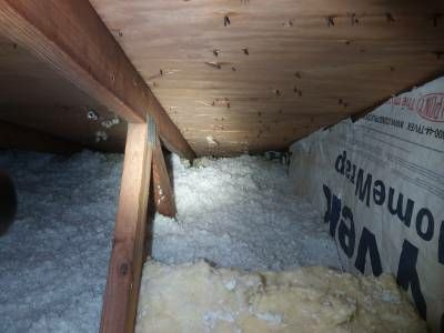 Blown-in insulation packed against the roof line where the soffit vents enter the attic
