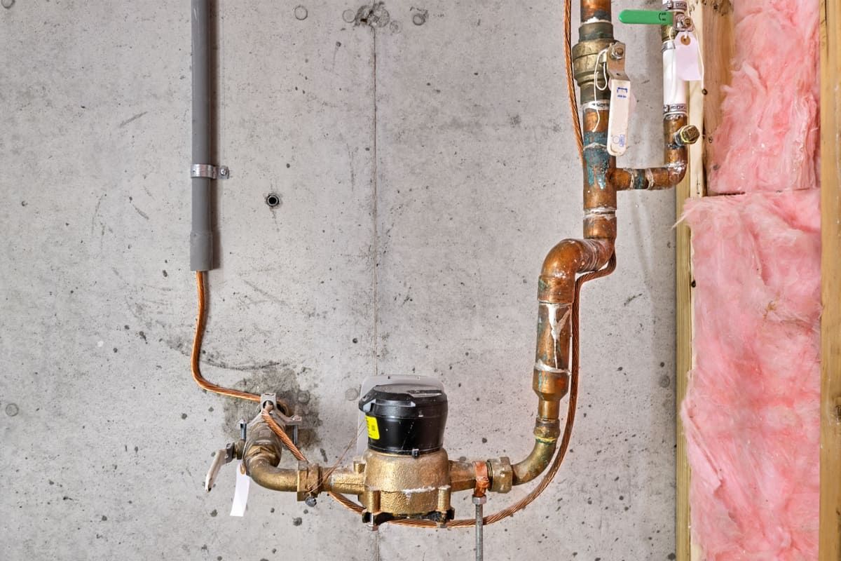 Main water line, meter and shutoff valve on a basement wall